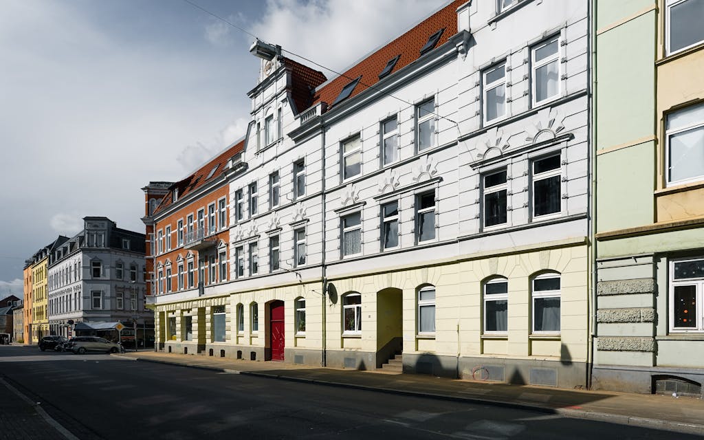 Old downtown Neumünster street showcasing classic German architecture under a cloudy sky.